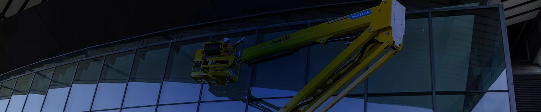 Plataforma articulada Haulotte realizando mantenimiento e instalación en fachada de cristal
