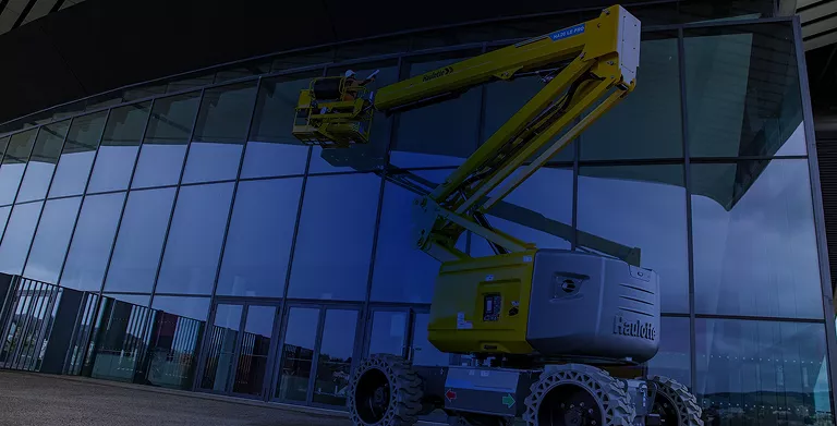 Plataforma articulada Haulotte realizando mantenimiento e instalación en fachada de cristal