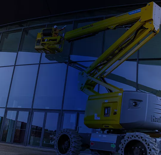 Plataforma articulada Haulotte realizando mantenimiento e instalación en fachada de cristal