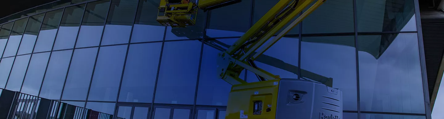 Plataforma articulada Haulotte realizando mantenimiento e instalación en fachada de cristal